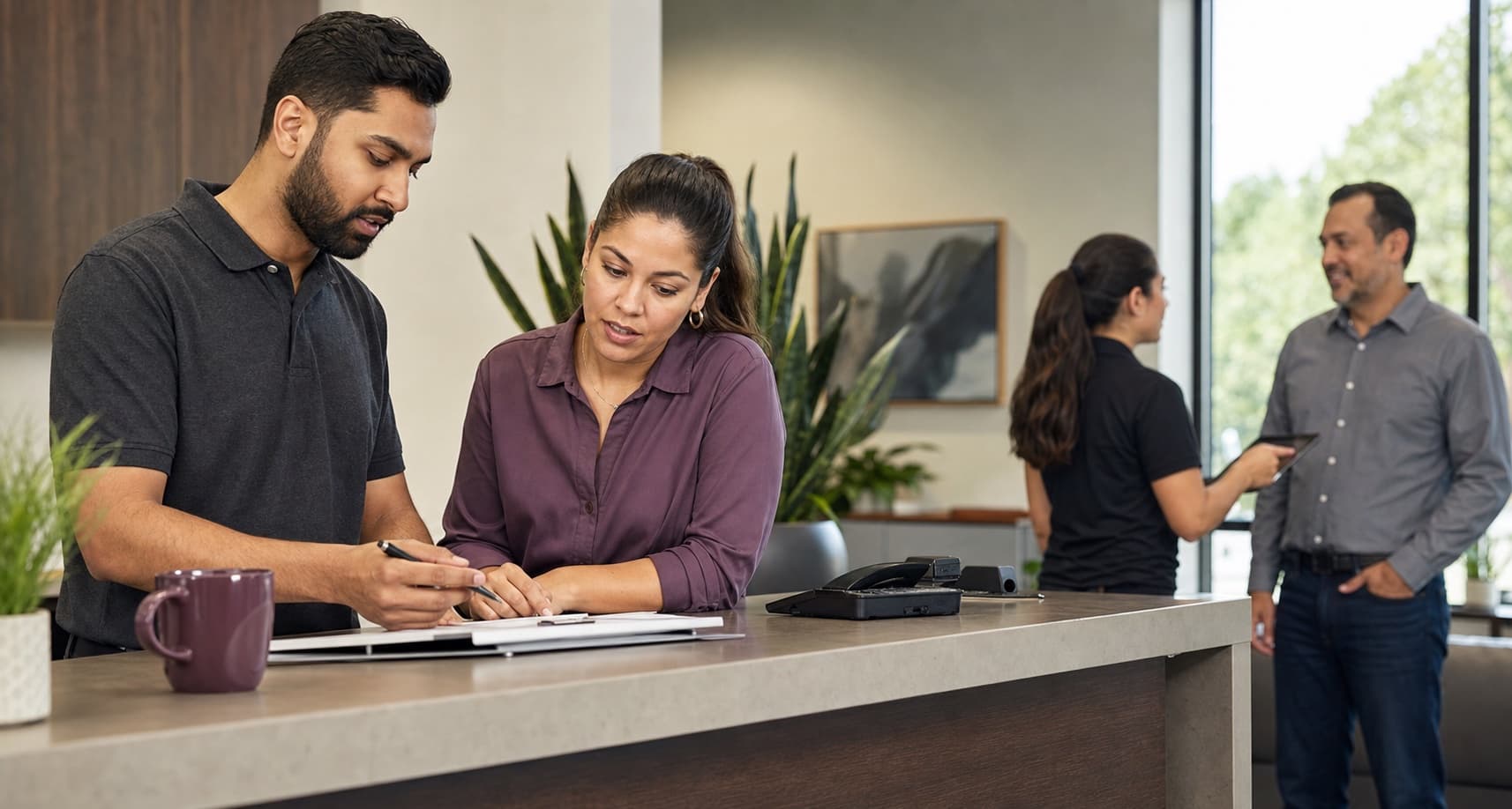 A service team reviewing customer work together at a reception counter